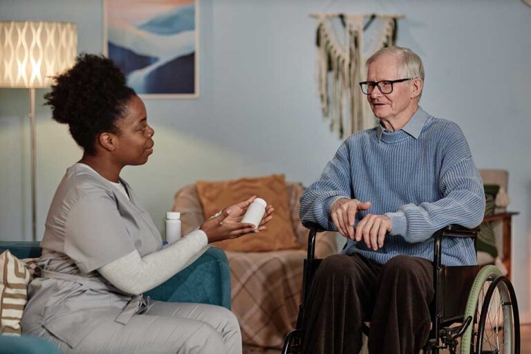 Caregiver reviews a personalized care plan with an older resident at a dining table.